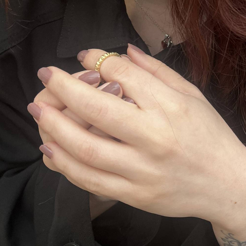 Shy Guy gold vermeil band ring styled on hand against dark background